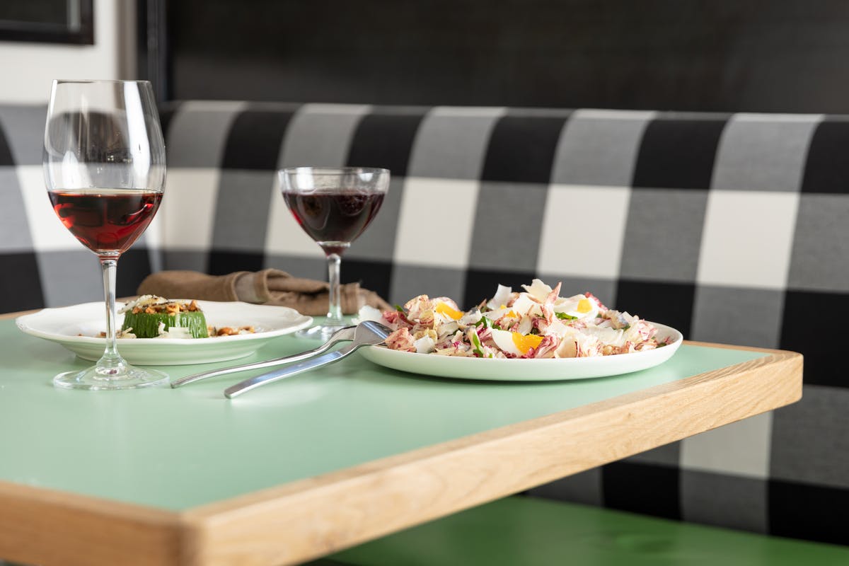 a glass of wine sitting on top of a wooden table